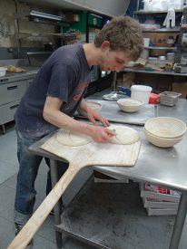 Peter Merzbacher scored sourdough boules with a razor before placing them in the oven.