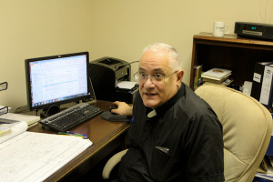 Father Domenic Rossi, the founder of Bethesda Project, working at his desk.