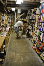 Tyler Lau sorts books in the basement storage area.