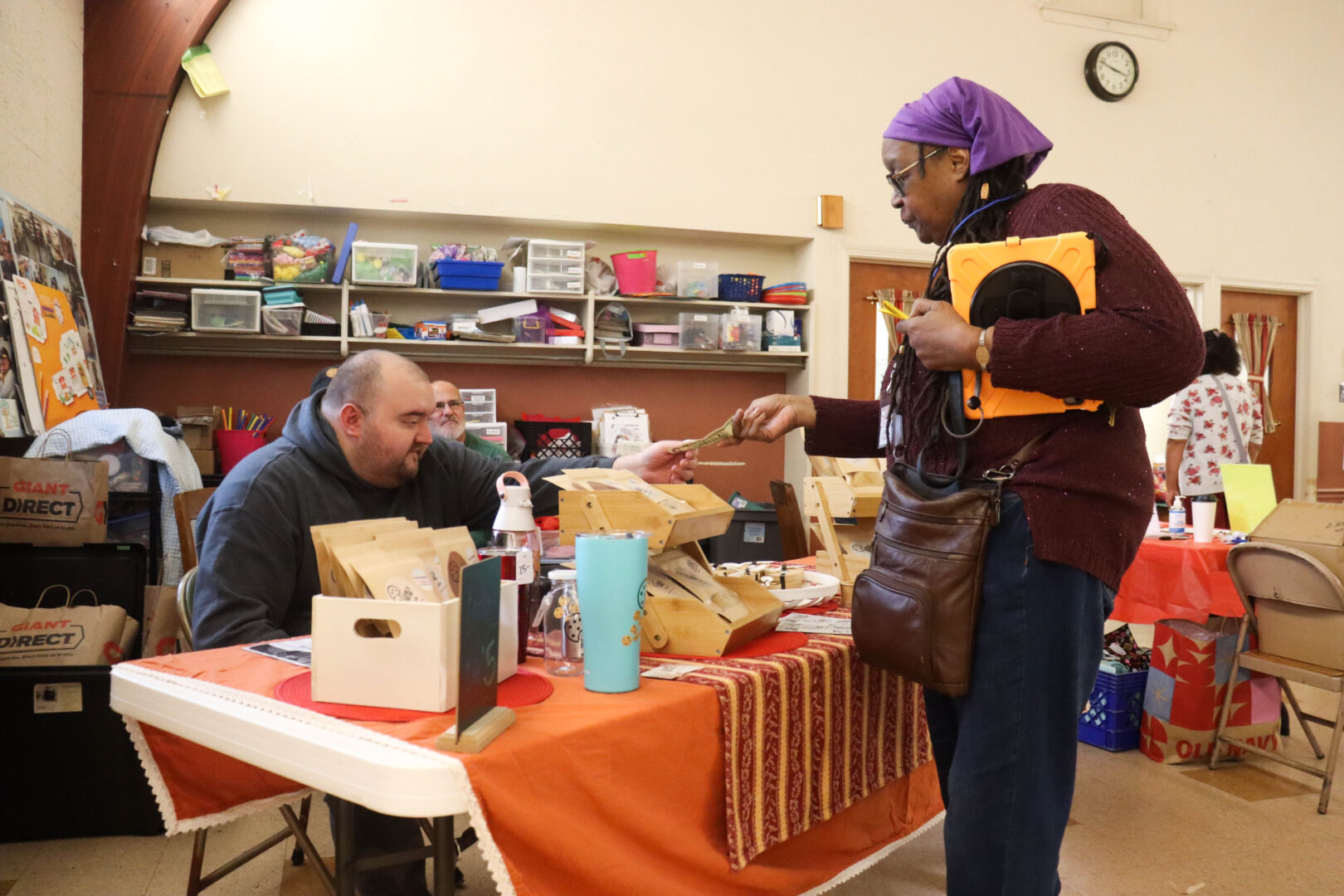 Someone sells goods to another person at an event for Families CCAN. This was the first ever in person event since the founding of the organization in 2013.