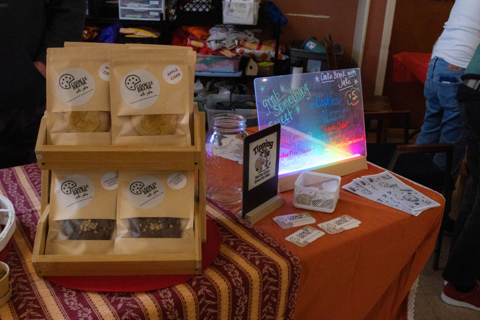 A display of packaged cookies and business cards at a vendor table.